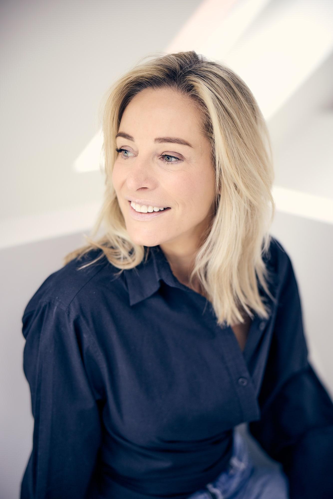 Virginie Versteegh in een donkerblauwe blouse, lachend