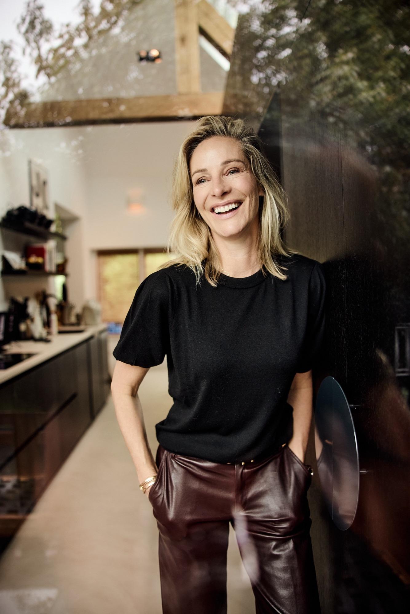 Virginie Versteegh in een zwarte top, lachend in een lichte keuken