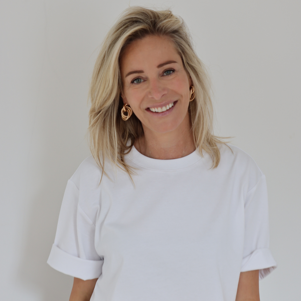 Virginie Versteegh, lachend in een wit T-shirt tegen een lichte achtergrond